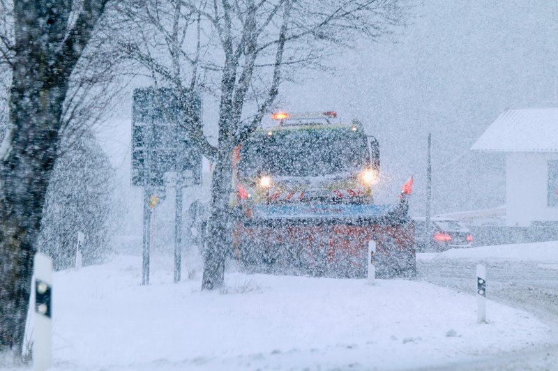 Ein Schneemobil räumt schließlich die Straße frei und entfernt das Schneeauto.