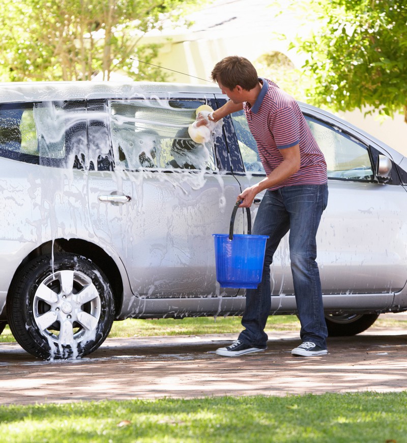 Eine Familie wäscht ihr eigenes Auto.