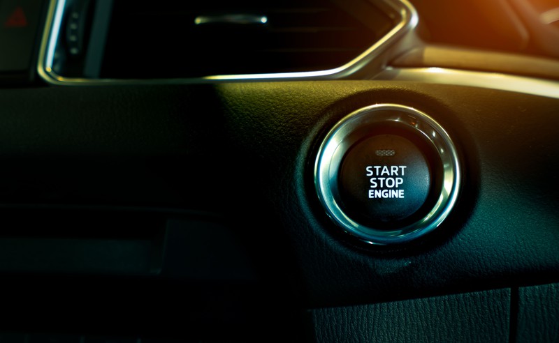 Zu sehen ist der Power-Knopf in einem Auto.