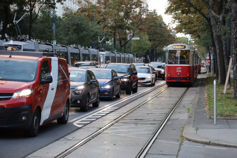 Zu sehen ist eine Straßenbahn, die stehende Autos überholt.