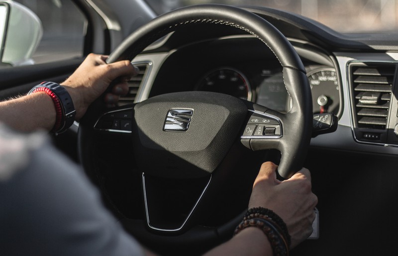 Man sieht das Logo von Seat mit den Händen des Fahrers