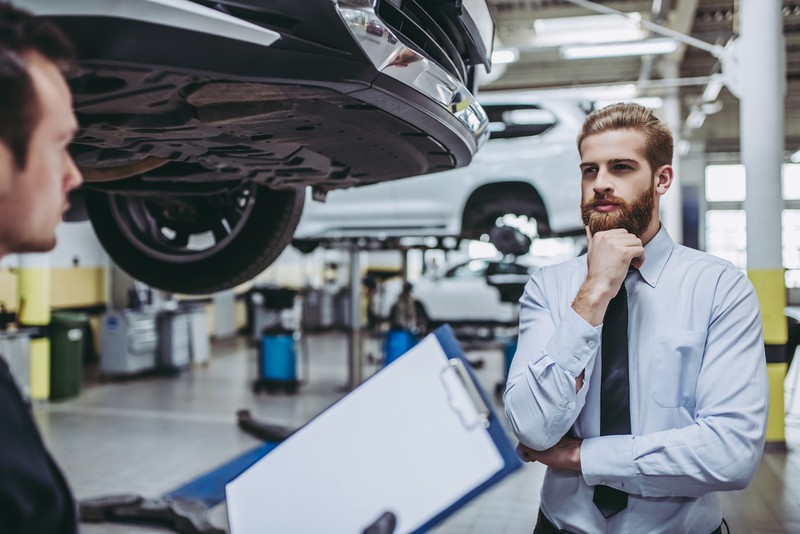 Ein Mann steht in einer Auto-Werkstatt, die ihn potentiell abzocken könnte