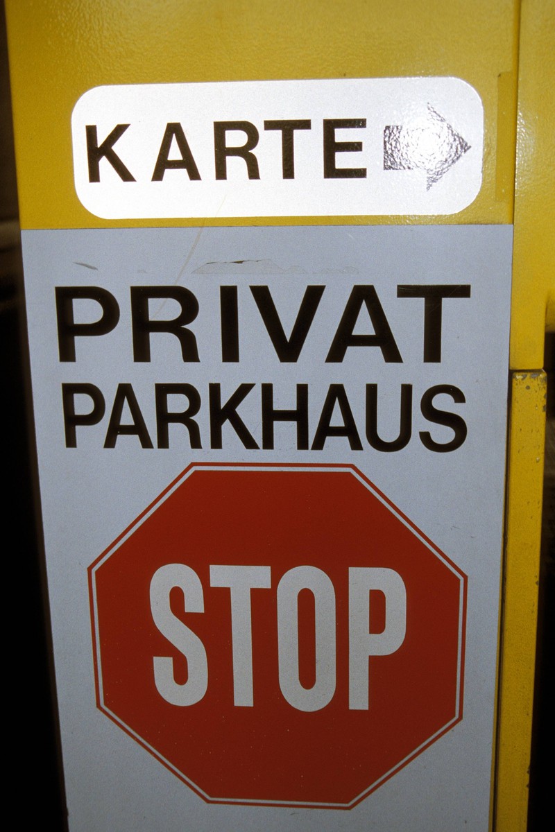 Man erkennt ein Schild, das aussagt, dass das Hausrecht des Betreibers gilt und das Parkhaus privat ist