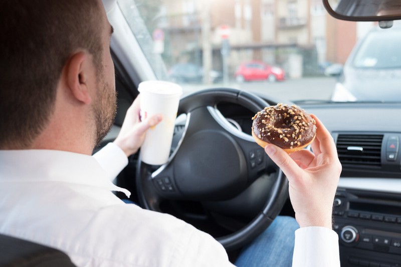 Viele Autofahrer essen während der Autofahrt, obwohl man eine Teilschuld bei einem Unfall bekommen kann.
