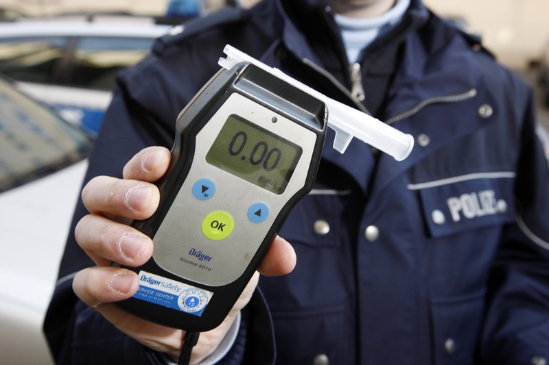 Ein Polizist hält ein Testgerät zur Überprüfung des Atemalkohols in der Hand