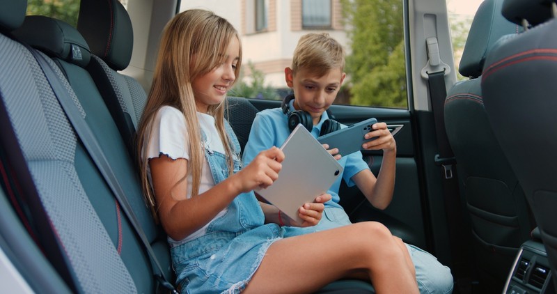 Spiele, Filme und Hörbücher sorgen bei langen Autofahrten für entspannte Kinder.