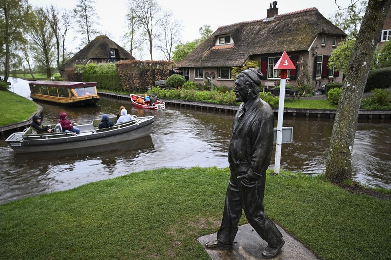 In Giethoorn in den Niederlanden sind die Menschen per Boot unterwegs.